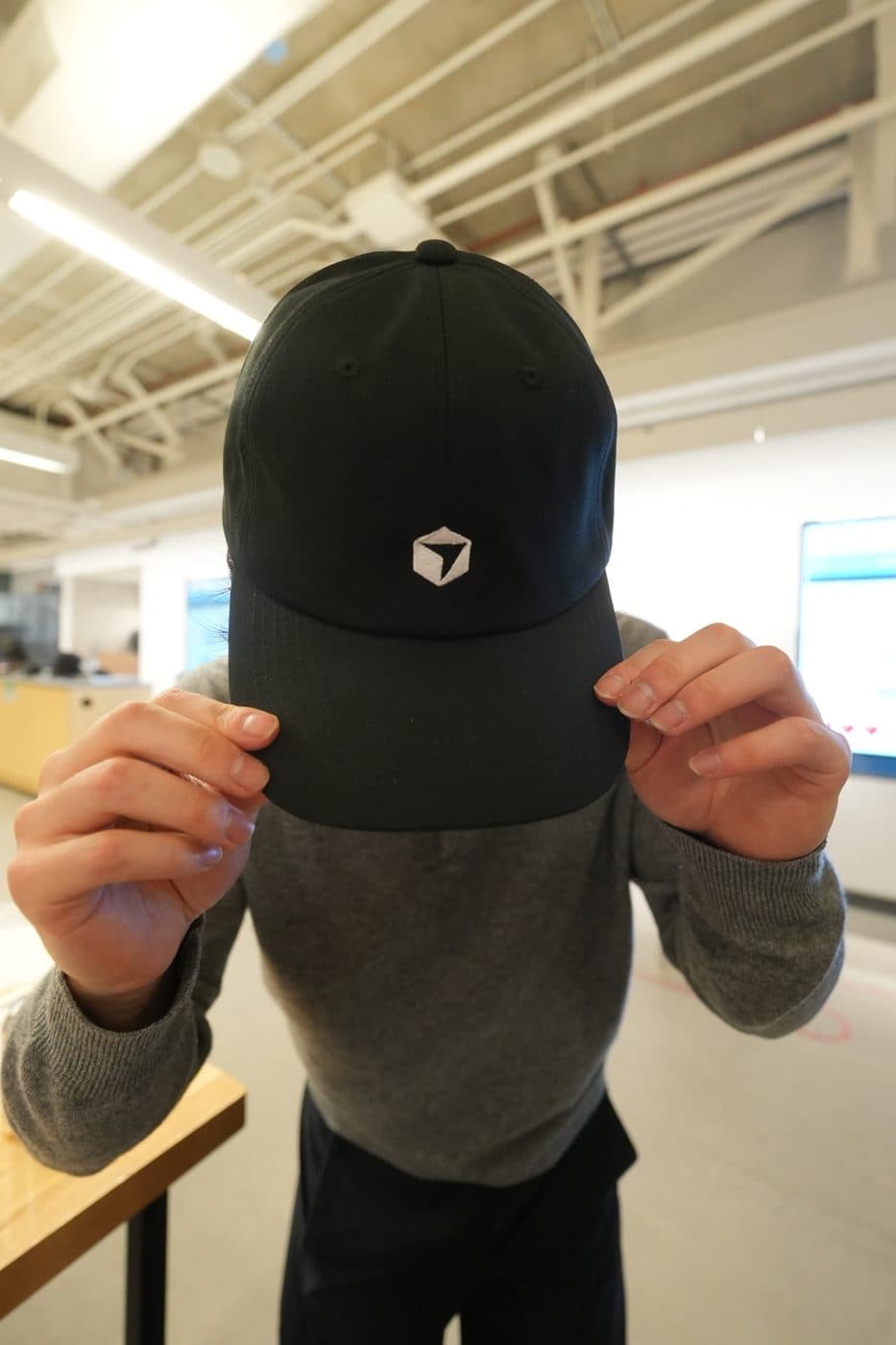 An attendee showing off a Cursor cap